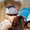 Cool kids mother and daughter hiking in the fields around Johannesburg wearing trail caps in teal / jade / gold and grey / black